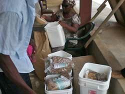 Filling pails with oats and rice etc. for distribution