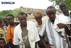 Village men wait for food distribution for their families